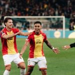 GoAheadEagles_Dean James_Celebration_Europe.webp Dean James dam Temannya merayakan gol di lapangan sepak bola, dengan senyum lebar dan saling merangkul, sementara seorang pemain lawan terlihat di latar depan. Keramaian penonton terlihat samar di latar belakang stadion