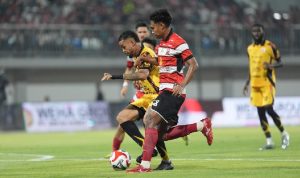 Persija-vs-Madura-United-Duel-Sepakbola-Kemenangan-Jawa-Timur.webp Pemain Persija (seragam merah-putih) berduel dengan pemain Madura United (seragam kuning-hitam) memperebutkan bola di lapangan.