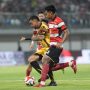 Pemain Persija (seragam merah-putih) berduel dengan pemain Madura United (seragam kuning-hitam) memperebutkan bola di lapangan.