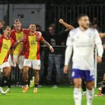 Go-Ahead-Eagles-Rayakan-Comeback-Aston-Villa-Dean-James.jpeg Pemain Go Ahead Eagles dengan seragam merah-kuning merayakan gol dengan ekspresi gembira di lapangan yang basah, sementara pemain lawan terlihat kecewa.