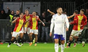 Go-Ahead-Eagles-Rayakan-Comeback-Aston-Villa-Dean-James.jpeg Pemain Go Ahead Eagles dengan seragam merah-kuning merayakan gol dengan ekspresi gembira di lapangan yang basah, sementara pemain lawan terlihat kecewa.