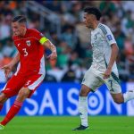 timnas-indonesia-vs-arab-saudi-aksi-lapangan.jpg Pemain Timnas Indonesia bernomor punggung 3, Jay Idzes berseragam merah menggiring bola di lapangan, dibayangi oleh pemain Timnas Arab Saudi berseragam putih