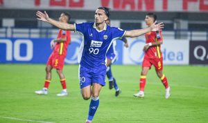 Persib-Bandung-Rayakan-Gol-Fase-Gugur-AFC-Champions-League-2.webp Pemain Persib Bandung, mengenakan seragam biru dengan nomor 90, merayakan gol dengan tangan terentang di lapangan.