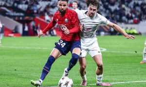 Calvin-Verdonk-Duel-Lille-Sepakbola-Asisst-Drama-Gol.jpg Calvin Verdonk, pemain Lille dengan seragam merah, berduel dengan pemain lawan berseragam putih di lapangan sepak bola.
