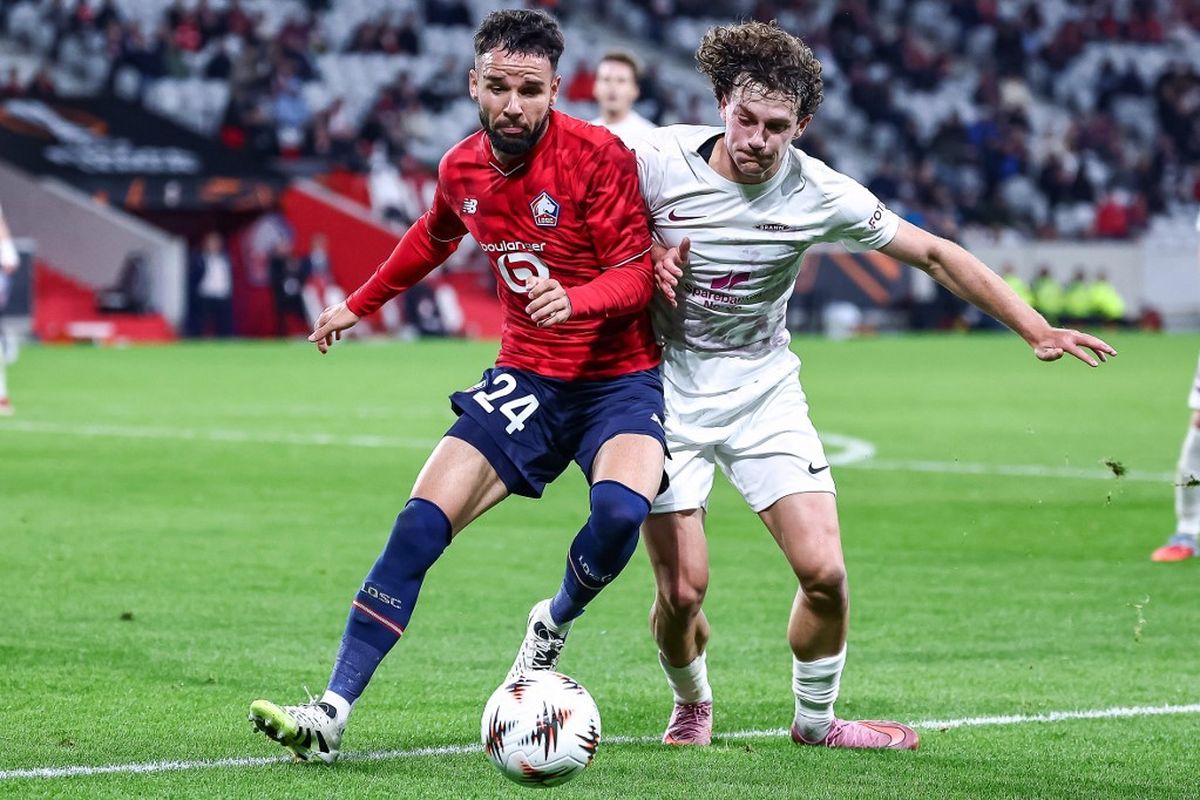 Calvin-Verdonk-Duel-Lille-Sepakbola-Asisst-Drama-Gol.jpg Calvin Verdonk, pemain Lille dengan seragam merah, berduel dengan pemain lawan berseragam putih di lapangan sepak bola.