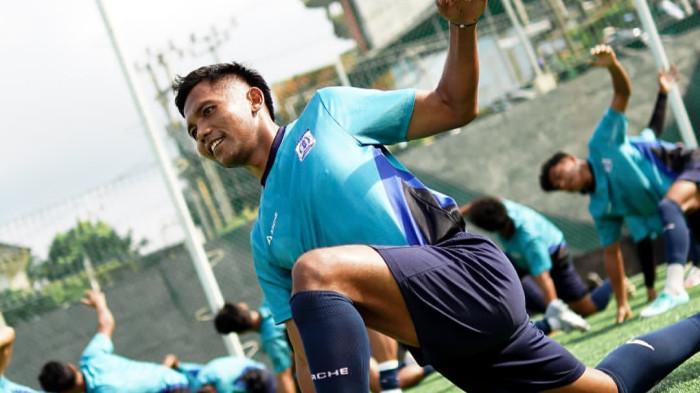 Persiba-Balikpapan-Latihan-Pemanasan-Jelang-Bangkit-Persiku-Kudus.webp Pemain Persiba Balikpapan, mengenakan seragam biru, melakukan pemanasan stretching di lapangan latihan sambil tersenyum.