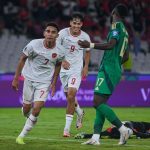 timnas-indonesia-pemain-lapangan-pertandingan.jpg Dua pemain Timnas Indonesia berseragam putih, satu dengan nomor punggung 7 dan yang lain 9, di dekat seorang pemain lawan berseragam hijau dan seorang kiper yang terjatuh di lapangan hijau.