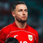 pemain-lini-tengah-timnas-indonesia-ekspresi-fokus.jpg Pemain Timnas Indonesia Marc Klok berseragam merah dengan lambang Garuda di dada, memiliki janggut tipis dan menatap ke samping dengan ekspresi serius.