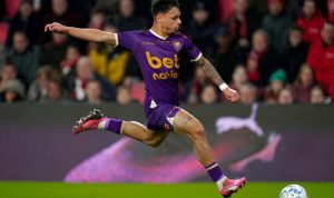 Pemain Go Ahead Eagles, Dean James, dalam action shot menendang bola di tengah pertandingan.