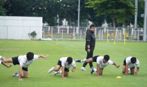 Pelatih Indra Sjafri mengawasi pemain Timnas Indonesia U-22 melakukan latihan fisik di lapangan hijau.