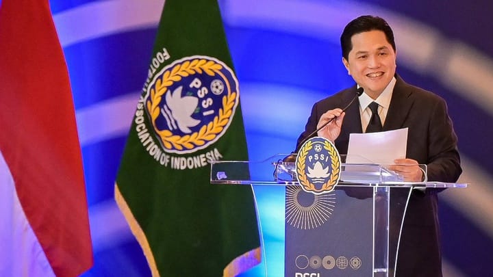 Ketua-PSSI-Erick-Thohir-Pidato-Piala-Asia-Pelatih-Timnas.webp Ketua PSSI Erick Thohir berpidato di podium, diapit bendera Indonesia dan logo PSSI, terkait pencarian pelatih Timnas.