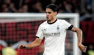 Kevin-Diks-Monchengladbach-Piala-Liga-Jerman-Tak-Tergantikan.jpg Pemain sepak bola Kevin Diks mengenakan seragam putih Monchengladbach, dengan tatapan fokus di lapangan.