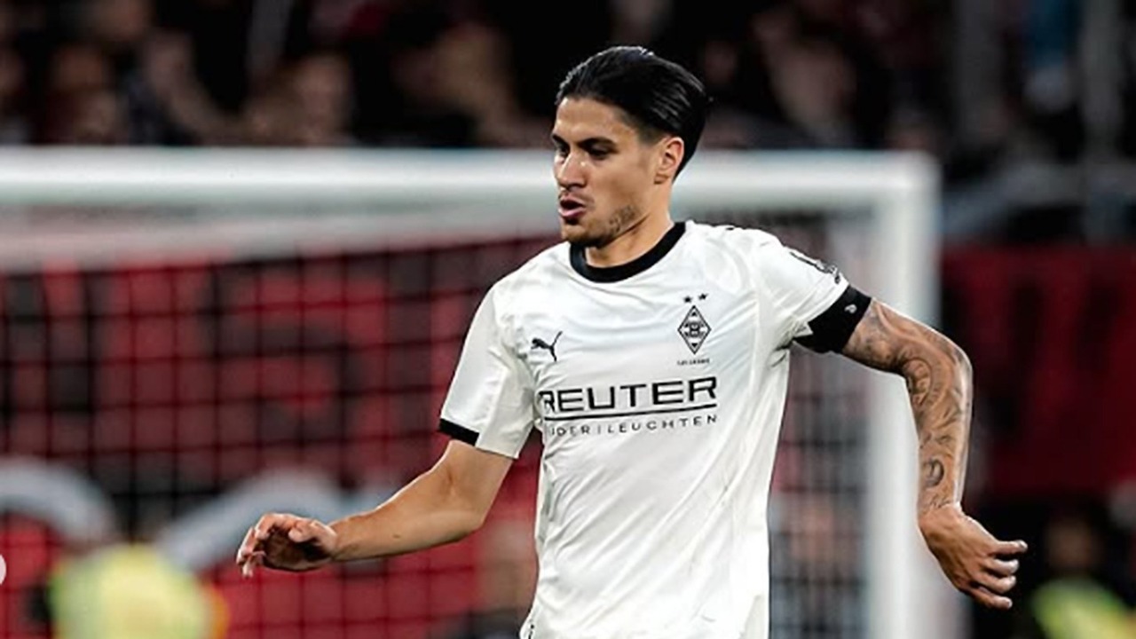 Kevin-Diks-Monchengladbach-Piala-Liga-Jerman-Tak-Tergantikan.jpg Pemain sepak bola Kevin Diks mengenakan seragam putih Monchengladbach, dengan tatapan fokus di lapangan.