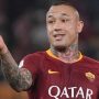 Pemain sepak bola Radja Nainggolan (seragam AS Roma) dengan tato di leher dan lengan, memberikan isyarat tangan.