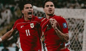 Dua pemain Timnas Indonesia berseragam merah merayakan gol dengan ekspresi gembira dan emosional di lapangan sepak bola.