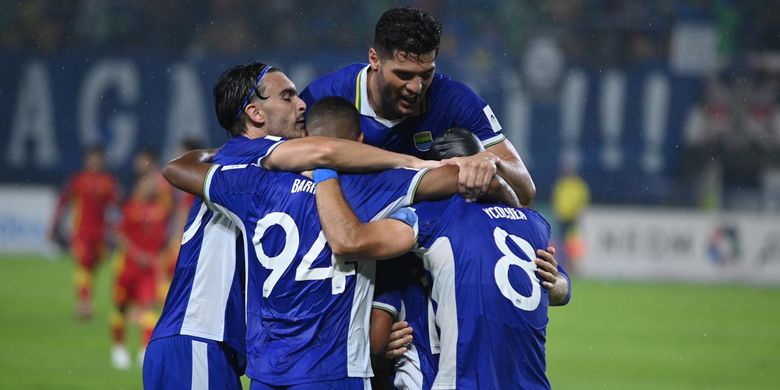 Persib-Bandung-Rayakan-Gol-Liga-Champions-Asia-2-Selangor-FC.webp Pemain Persib Bandung dengan seragam biru merayakan gol bersama di lapangan sepak bola, saling berpelukan erat.