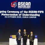 Upacara penandatanganan Memorandum of Understanding (MoU) antara ASEAN dan FIFA di Kuala Lumpur, menampilkan tiga tokoh penting di panggung.