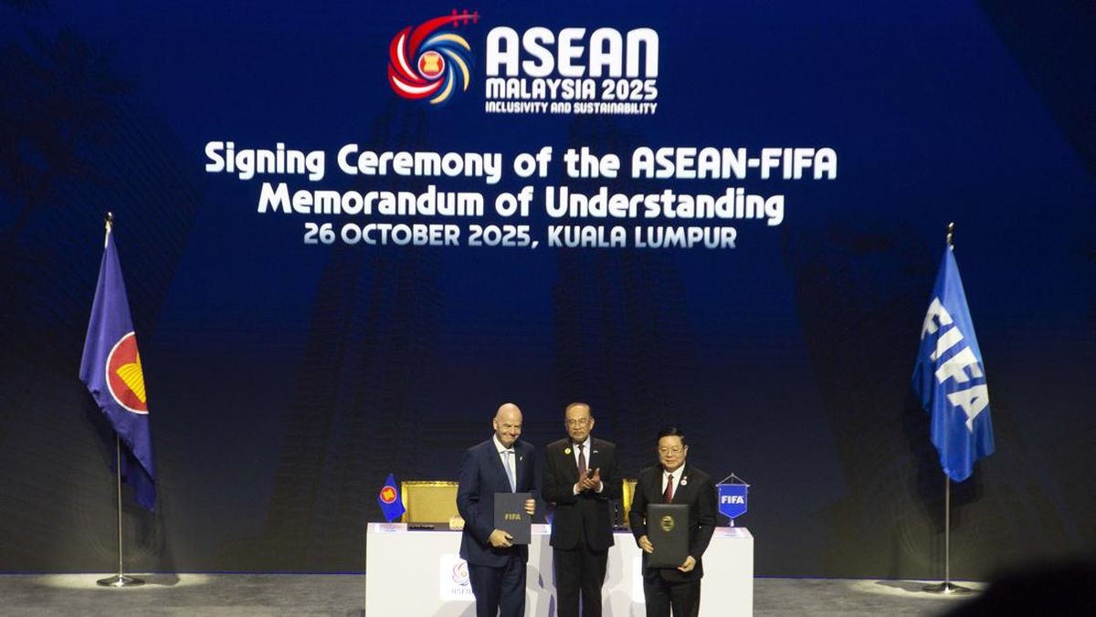 Signing-Ceremony-ASEAN-FIFA-MoU-Kuala-Lumpur-PSSI-Respons.webp Upacara penandatanganan Memorandum of Understanding (MoU) antara ASEAN dan FIFA di Kuala Lumpur, menampilkan tiga tokoh penting di panggung.