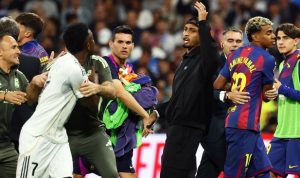 Vinicius-Junior-Ketegangan-El-Clasico-Courtois-Lamine-Yamal.jpg Vinicius Junior berdebat dengan pemain Barcelona di El Clasico, dengan Courtois dan Lamine Yamal terlihat di latar belakang, memicu ketegangan di lapangan.