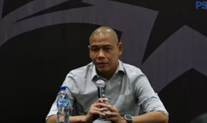 Pelatih Nova Arianto (mengenakan jersey Timnas Indonesia) sedang memberikan instruksi atau menunjuk ke arah lapangan.