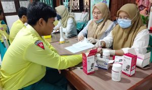 Petugas kesehatan dari Puskesmas Gunung Samarinda sedang melakukan pemeriksaan kesehatan (misalnya mengukur tinggi atau menimbang berat badan) kepada siswa SMK Nusantara.