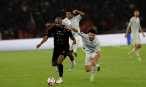 Pemain Persija Jakarta (kostum merah) merayakan gol atau kemenangan dengan gembira, menyimbolkan sukses di hari ulang tahun klub.