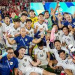Seluruh skuad dan staf Timnas Indonesia U-17 merayakan kemenangan bersama di lapangan dengan sorak-sorai di depan tribun penonton.