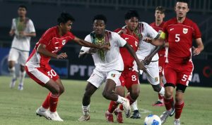 Pemain Timnas Indonesia U-22 berebut bola dengan pemain Mali dalam pertandingan persahabatan, dengan ekspresi tegang.