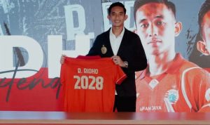 Rizky Ridho berpose sambil memegang jersey Persija dengan nama "R. RIDHO" dan nomor "2028", menandai perpanjangan kontraknya.