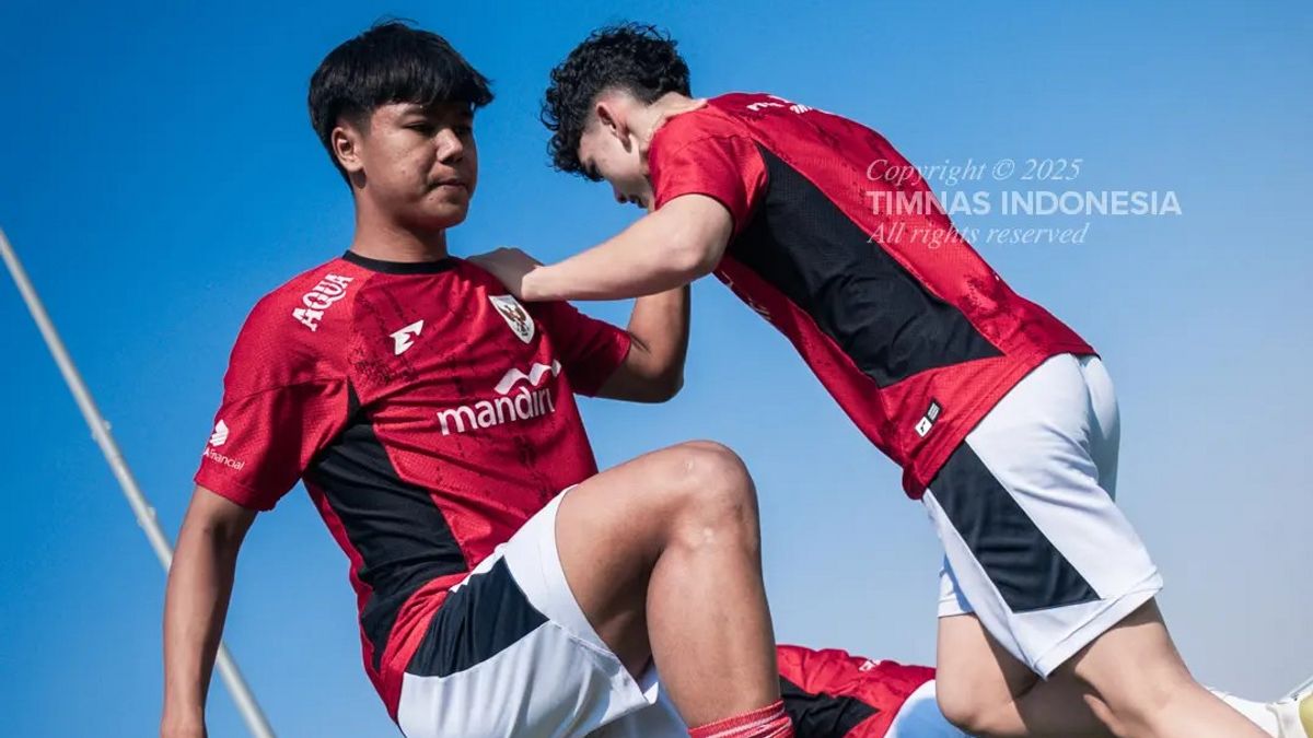 Dua pemain Timnas Indonesia U-17 dalam seragam merah sedang melakukan peregangan atau latihan fisik, menunjukkan persiapan serius jelang pertandingan.