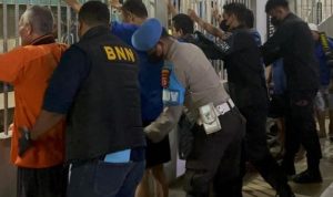 Petugas BNN dan POLRI (berseragam biru) bersama petugas lainnya melakukan razia gabungan di Lapas Balikpapan, memeriksa para narapidana di balik jeruji besi.
