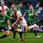 Genoa-vs-Sassuolo-Perebutan-Bola-Liga-Italia.jpg Pemain sepak bola dari tim Genoa (seragam putih-merah) dan Sassuolo (seragam hijau-hitam) berebut bola dalam pertandingan sengit di lapangan hijau.