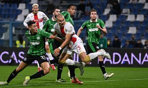 Genoa-vs-Sassuolo-Perebutan-Bola-Liga-Italia.jpg Pemain sepak bola dari tim Genoa (seragam putih-merah) dan Sassuolo (seragam hijau-hitam) berebut bola dalam pertandingan sengit di lapangan hijau.