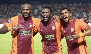 Pemain Borneo FC (kostum oranye) sedang melakukan selebrasi atau menunjukkan aksi di lapangan, menandakan performa tak terkalahkan.