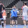 Deretan pemain Timnas Futsal Indonesia (mengenakan kaus merah) berdiri di lapangan dengan latar belakang tribun stadion.