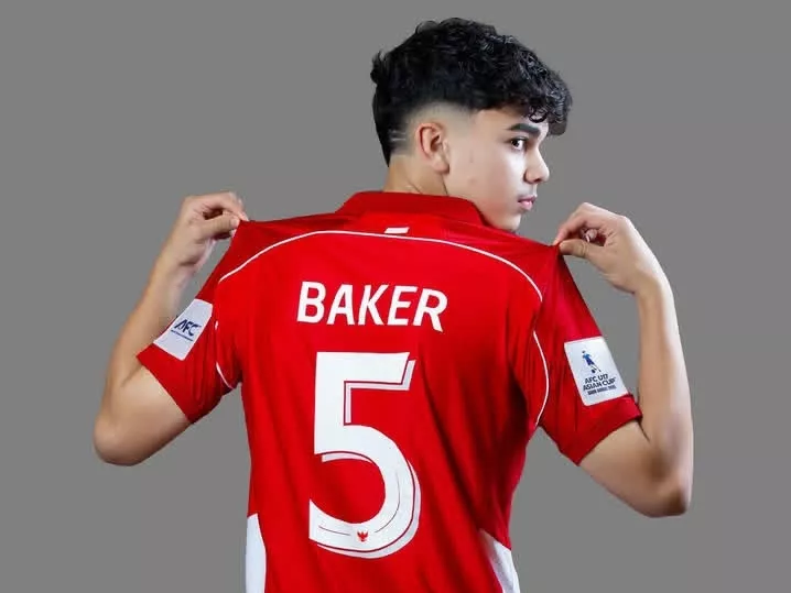 Nomor-Punggung-Pemain-Timnas-U17-Piala-Dunia-2025-Baker-5.webp Pemain muda Timnas U-17 Indonesia (bernama BAKER) memegang kerah jersey merah dengan nomor punggung 5 yang besar.