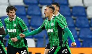 Pemain Sassuolo (kostum hijau hitam) sedang merayakan gol atau menunjukkan ekspresi intens selama pertandingan.