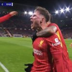 Liverpool-Rayakan-Gol-Liga-Champions-vs-Madrid.jpg Pemain Liverpool berseragam merah merayakan gol dengan teriakan kegembiraan, memeluk rekan setim di lapangan, menunjukkan skor "LIV 1-0 RMA" di papan skor.