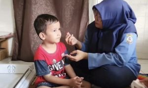 Petugas kesehatan atau penyuluh sedang memberikan edukasi kebersihan dan kesehatan kepada masyarakat untuk Kasus Cacingan, menyimbolkan peningkatan kesadaran.