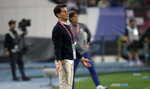 Potret seorang pelatih asing yang tampak fokus mengamati pertandingan, menyimbolkan kandidat kuat untuk posisi Pelatih Timnas Indonesia.