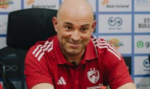 Bernardo Tavares mengenakan polo shirt hitam sedang memberikan instruksi taktis di pinggir lapangan latihan.