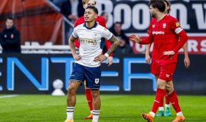 Pemain Dean James dari Go Ahead Eagles (jersey putih-biru tua) berdiri dengan ekspresi frustrasi atau kecewa di lapangan usai kekalahan dari Twente.