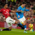 Pemain Manchester United melakukan tekel untuk merebut bola dari pemain lawan dalam pertandingan Premier League di Old Trafford.