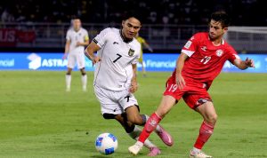 Pemain Timnas Indonesia bernomor punggung 7, Marselino Ferdinan, sedang berduel bola melawan pemain lawan di lapangan hijau.