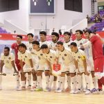 Foto skuad lengkap Timnas Futsal Indonesia yang mengenakan jersey putih berpose sebelum pertandingan.