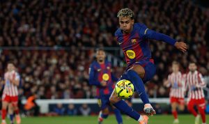 Pemain Barcelona (berjersey biru-merah) mengontrol bola dengan mahir selama pertandingan melawan Atletico Madrid.