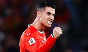 Selebrasi penuh semangat Cristiano Ronaldo saat membela Timnas Portugal dengan ekspresi wajah yang gigih dan tangan mengepal.