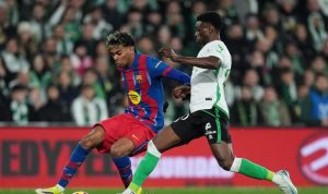 Lamine Yamal dari Barcelona sedang mendribel bola melewati pemain Racing Santander dalam pertandingan Racing Santander vs Barcelona.