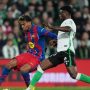 Lamine Yamal dari Barcelona sedang mendribel bola melewati pemain Racing Santander dalam pertandingan Racing Santander vs Barcelona.