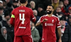 Mohamed Salah tersenyum lebar bersama Virgil van Dijk saat merayakan salah satu dari enam gol dominan Liverpool ke gawang Qarabag di Anfield.